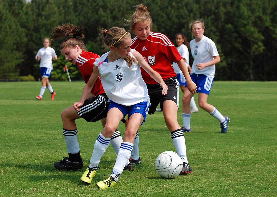 Youth Girl Soccer Game. Action shot of actual game in progress. Players fight for control of the ball.