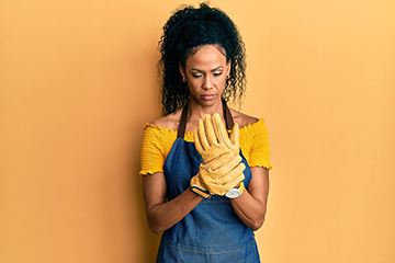 Middle age african american woman wearing professional apron suffering pain on hands and fingers